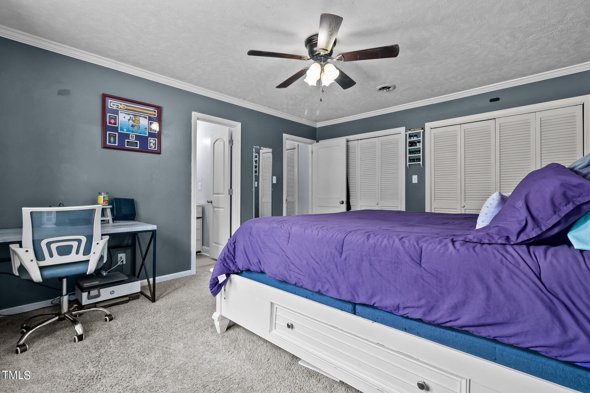 6262 Smithfield Road Wade, NC 28395 - Photo 23 of 53 a bedroom with a bed and a chandelier