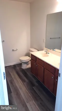 a bathroom with a granite countertop toilet and a sink