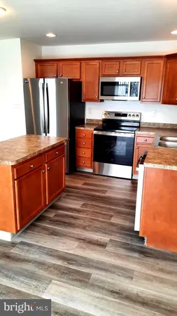 a kitchen with stainless steel appliances granite countertop a stove and a microwave