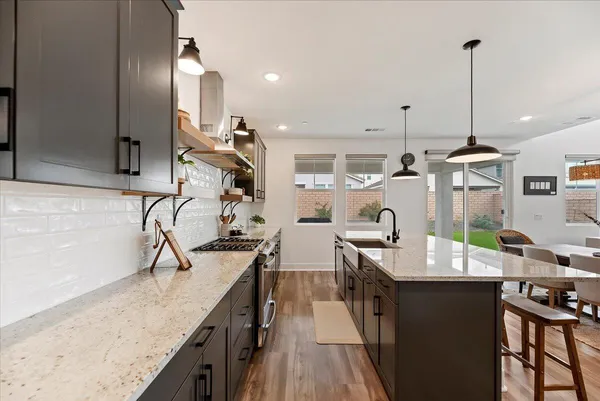 a kitchen with stainless steel appliances granite countertop sink stove and refrigerator
