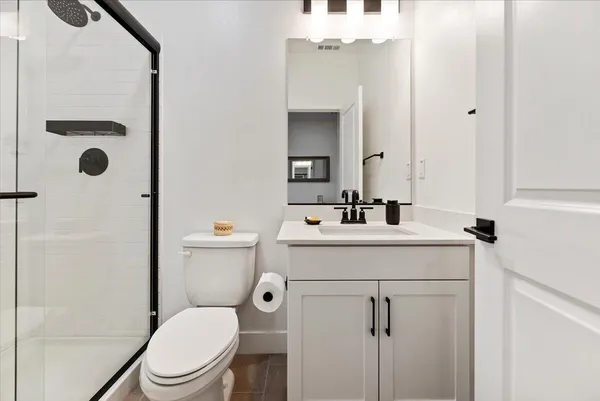 a bathroom with a sink a toilet and shower