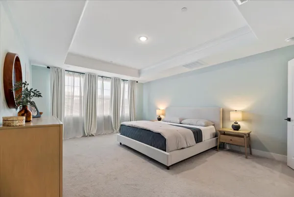 a spacious bedroom with a bed and a flat screen television