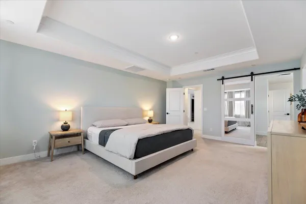 a spacious bedroom with a bed couch and a large window