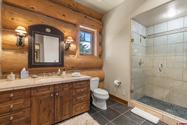 a bathroom with a double vanity sink toilet and shower