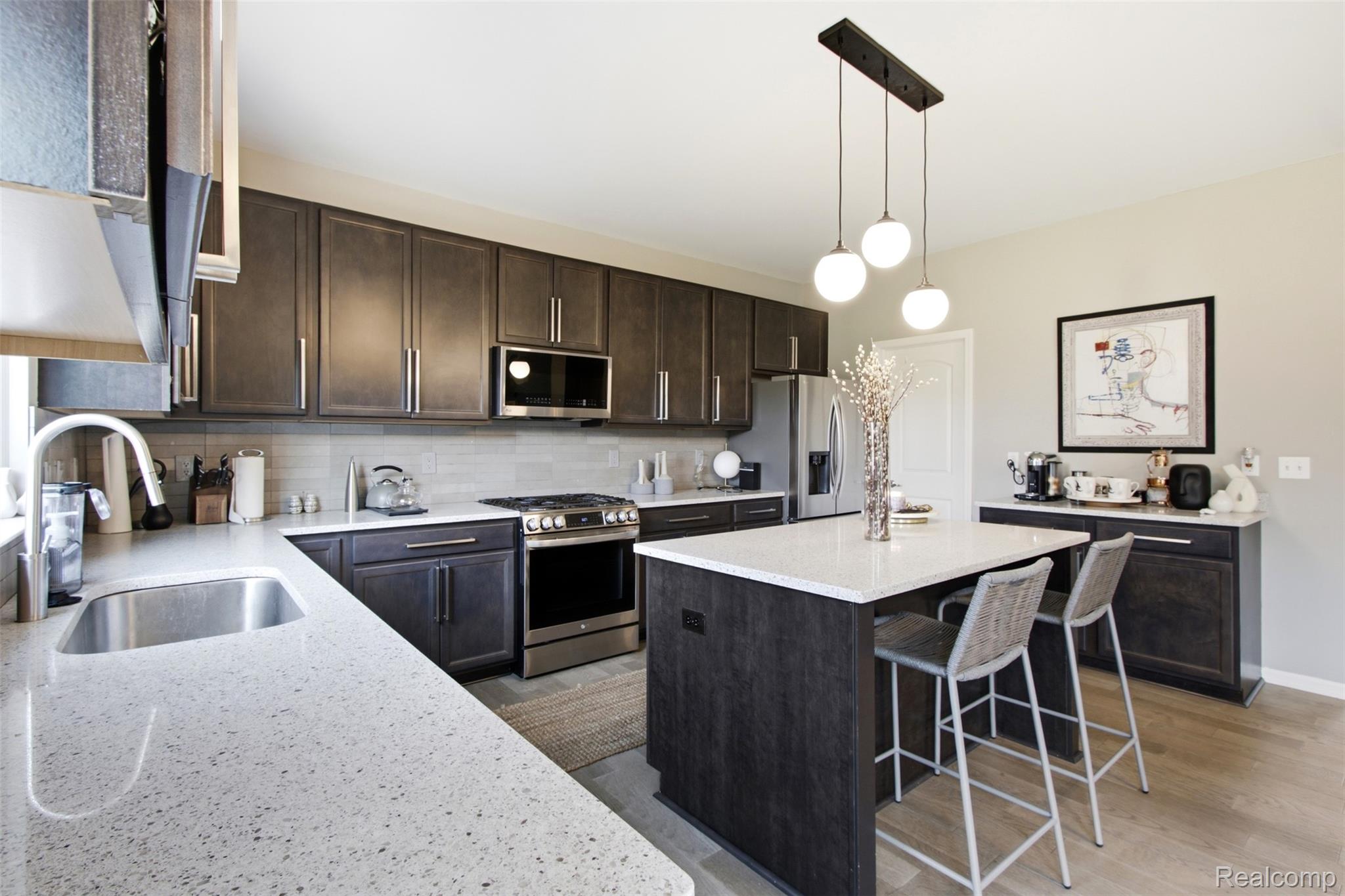 5085 Ridge Lane Warren, MI 48092 - Photo 13 of 29 Kitchen featuring dark wood-finish cabinetry, light speckled countertops, stainless steel appliances, and a tile backsplash