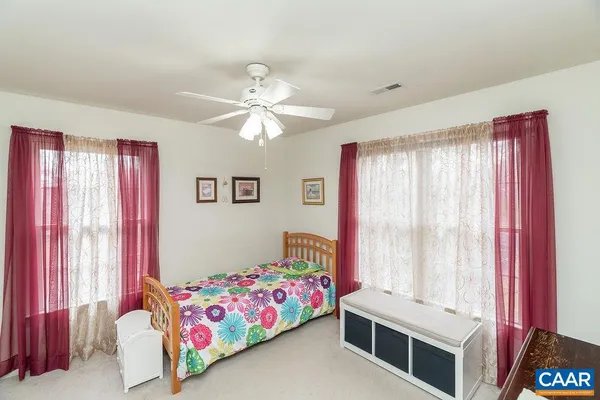 an empty room with wooden floor closet and windows