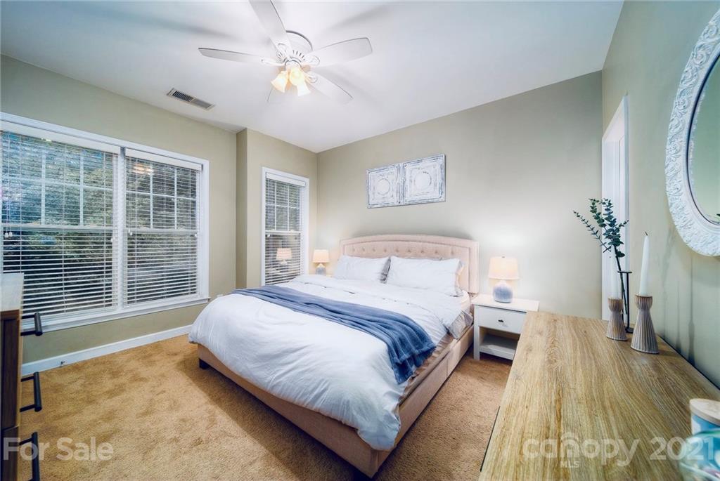 4142 Walker Road Charlotte, NC 28211 - Photo 8 of 18 a spacious bedroom with a large bed and a chandelier