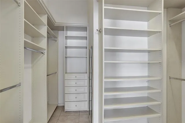 a view of walk in closet with empty racks