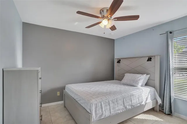 a bedroom with a large bed and a ceiling fan