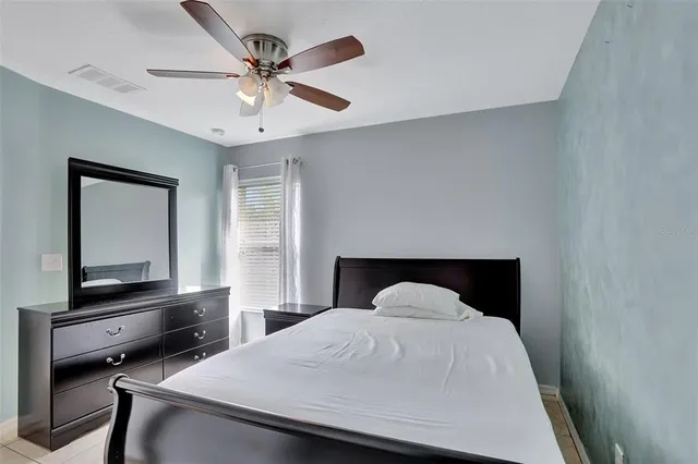 a bedroom with a bed and a flat tv screen on dresser