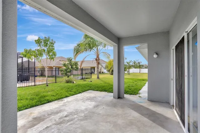 a view of a house with a big yard and large windows