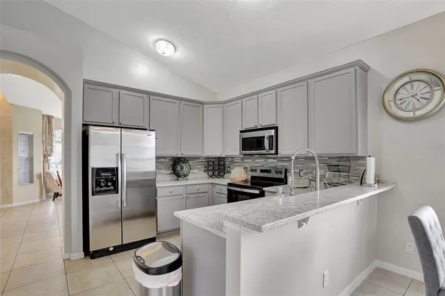 a kitchen with stainless steel appliances granite countertop a refrigerator a stove a sink and a refrigerator