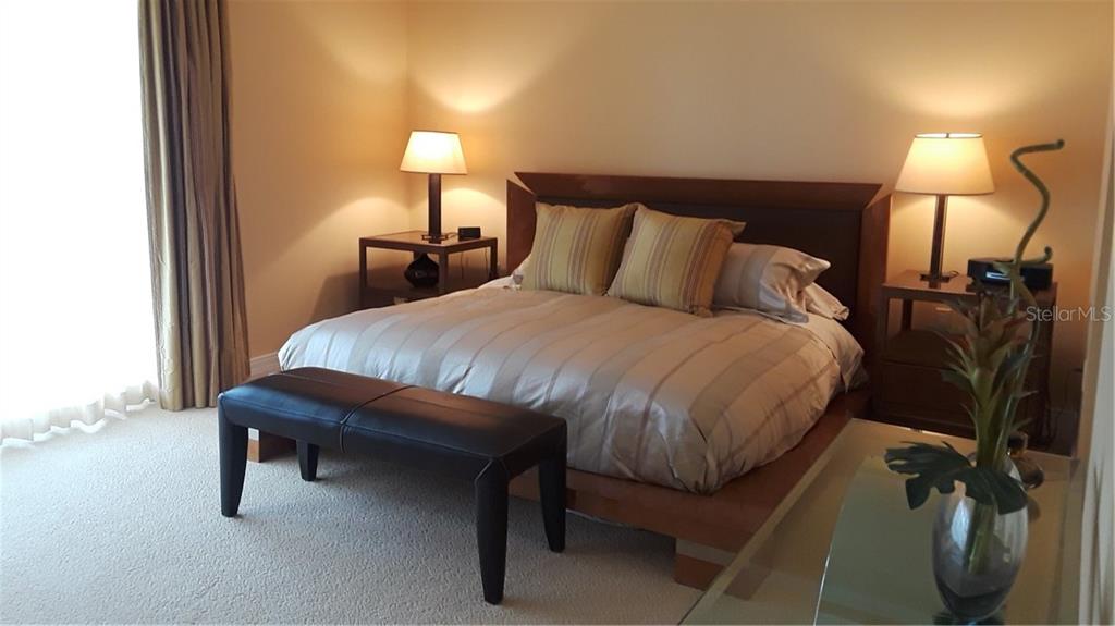 455 Longboat Club Road, Unit 401 Longboat Key, FL 34228 - Photo 11 of 28 a bedroom with a bed and a night stand