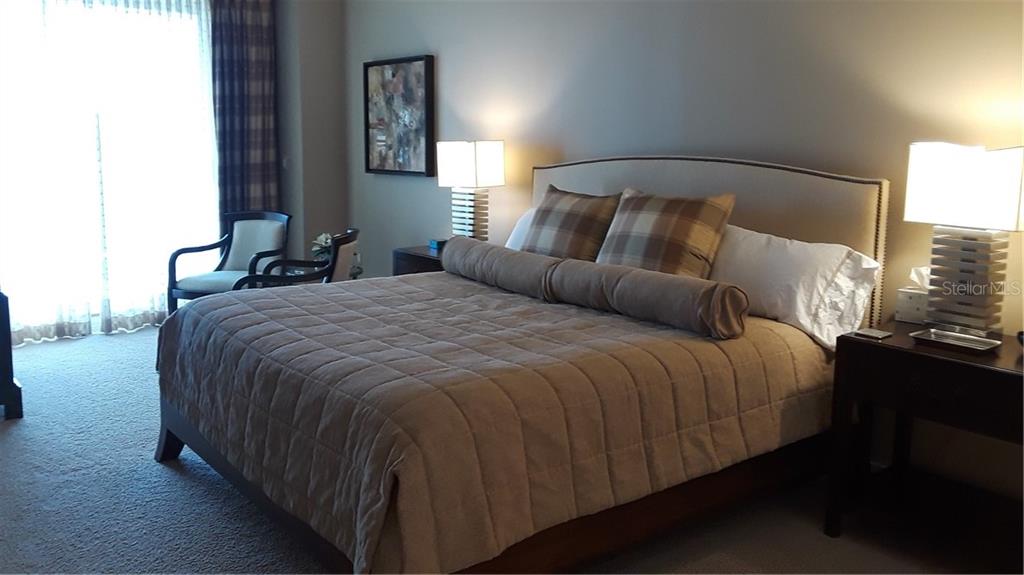 455 Longboat Club Road, Unit 401 Longboat Key, FL 34228 - Photo 16 of 28 a bedroom with a bed and a night stand