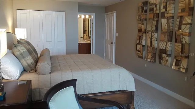 a bedroom with a bed and closet with mirror