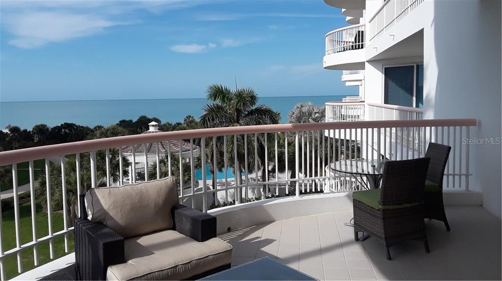 455 Longboat Club Road, Unit 401 Longboat Key, FL 34228 - Photo 25 of 28 a balcony with wooden floor and outdoor seating