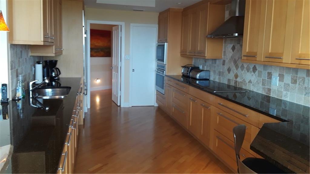 455 Longboat Club Road, Unit 401 Longboat Key, FL 34228 - Photo 10 of 28 a kitchen with stainless steel appliances granite countertop a refrigerator and a sink