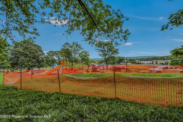 a view of a tennis ground with large trees
