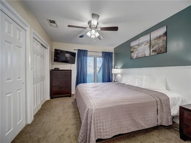a bedroom with a bed and a ceiling fan
