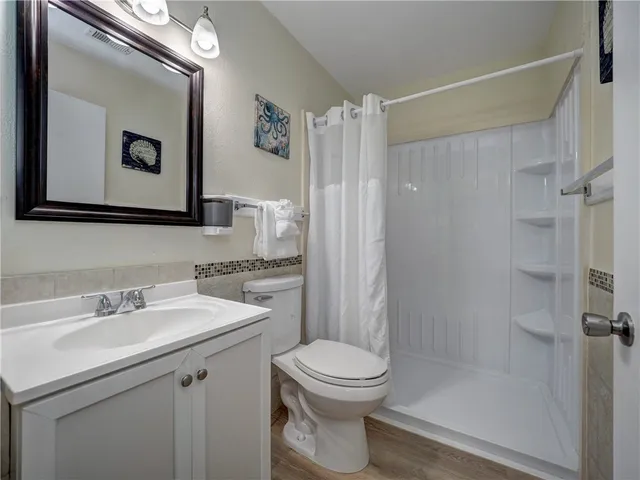 a bedroom with a bed and a lamp on dresser