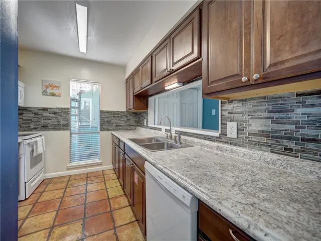 a kitchen with stainless steel appliances granite countertop a sink stove and cabinets
