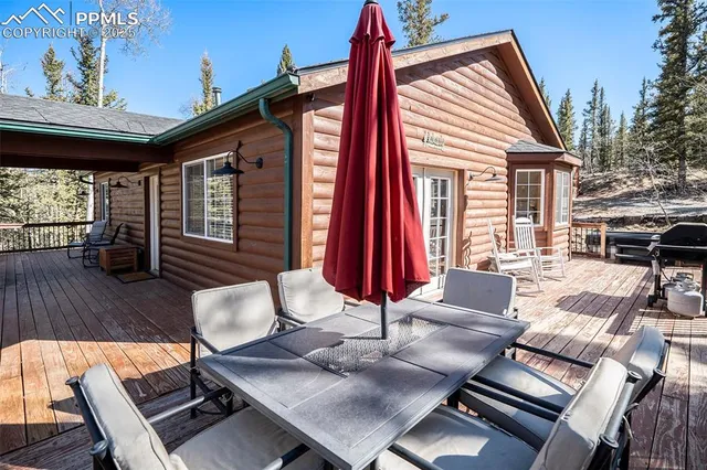 a view of a patio with a dining table and chairs with wooden floor and fence