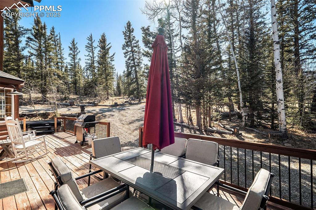 654 Piute Way Como, CO 80432 - Photo 21 of 25 a view of a patio with a dining table and chairs with wooden floor and fence