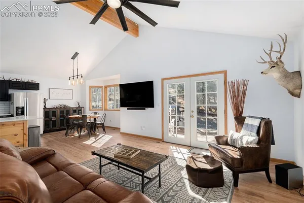 a living room with furniture a flat screen tv and a floor to ceiling window