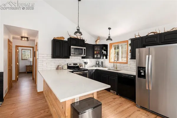 a kitchen with refrigerator cabinets and wooden floor