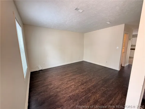 an empty room with wooden floor and entrance