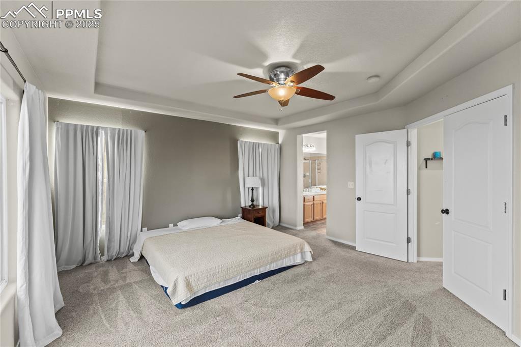 10173 Angeles Road Peyton, CO 80831 - Photo 23 of 50 a bedroom with a large bed and a chandelier
