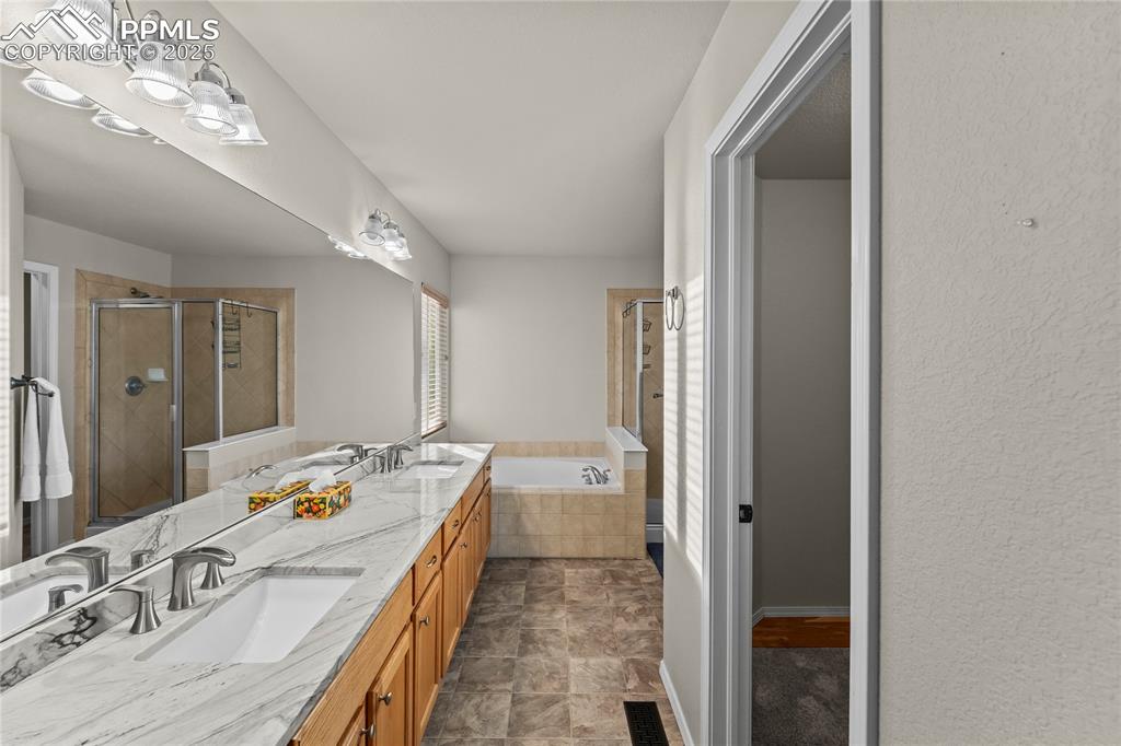 10173 Angeles Road Peyton, CO 80831 - Photo 25 of 50 a en suite spacious bathroom with a double vanity sink and mirror