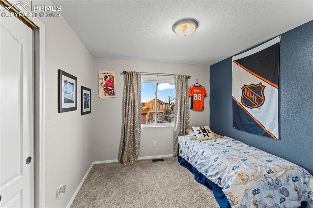 10173 Angeles Road Peyton, CO 80831 - Photo 27 of 50 a bedroom with a bed and painting on the wall