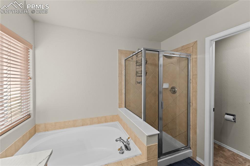 10173 Angeles Road Peyton, CO 80831 - Photo 28 of 50 a bathroom with a bathtub and a shower