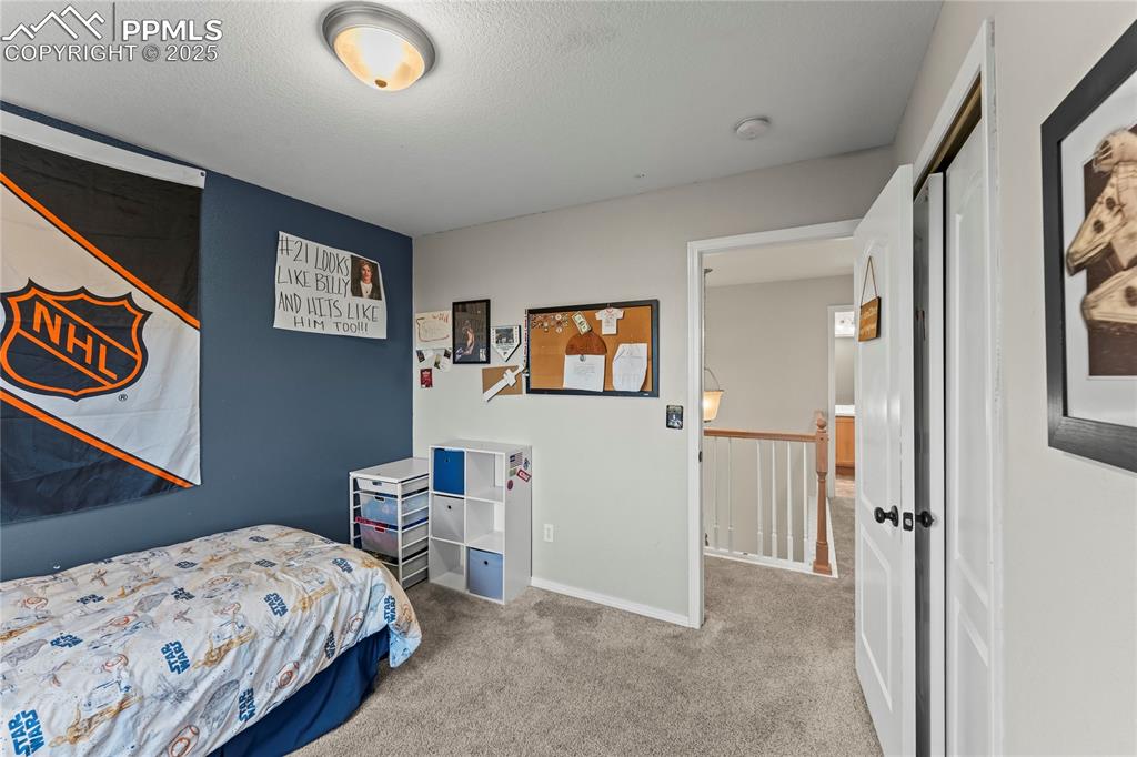 10173 Angeles Road Peyton, CO 80831 - Photo 29 of 50 a bedroom with a bed and a lamp on dresser