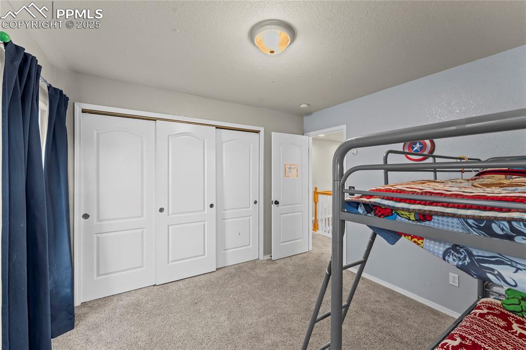 10173 Angeles Road Peyton, CO 80831 - Photo 32 of 50 a room that has a bed and a chandelier