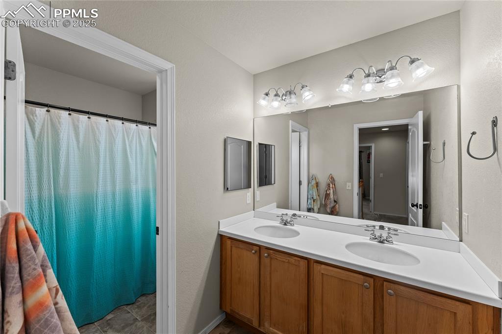 10173 Angeles Road Peyton, CO 80831 - Photo 33 of 50 a bathroom with a double vanity sink and a mirror