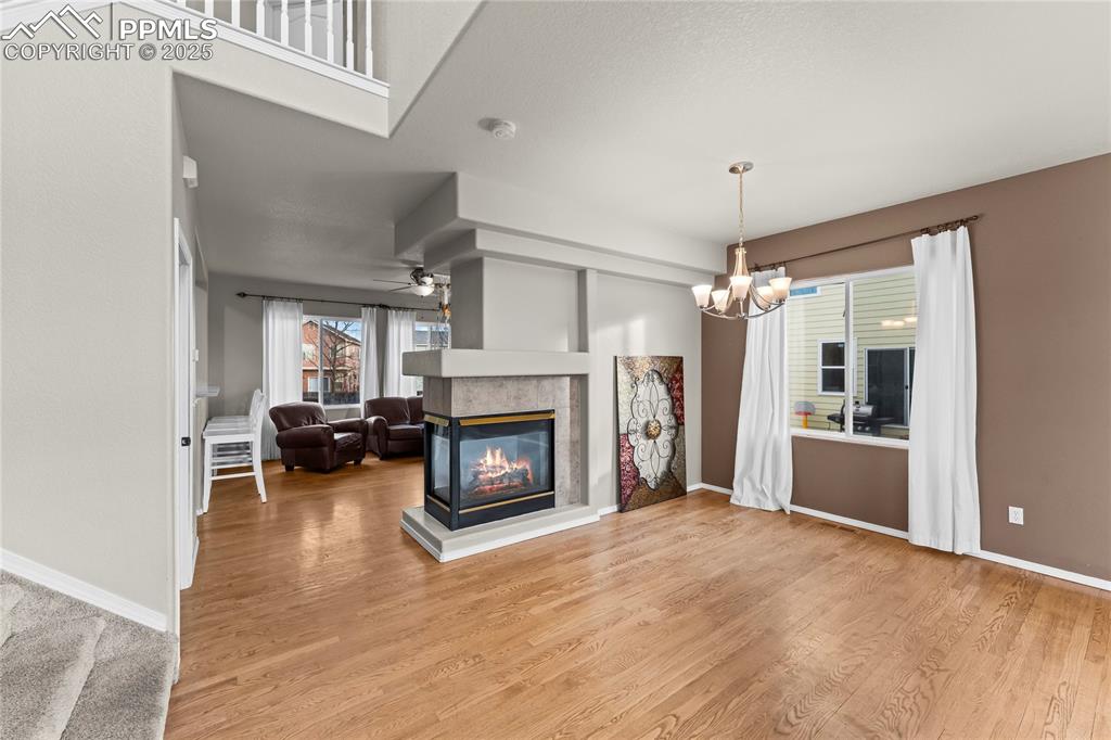 10173 Angeles Road Peyton, CO 80831 - Photo 6 of 50 a view of a livingroom with a fireplace a chandelier and wooden floor