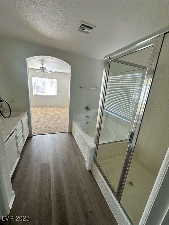 63 Puerto Azul Trail Henderson, NV 89074 - Photo 16 of 26 Full bath with a shower stall, a textured ceiling, ceiling fan, vanity, and a bath