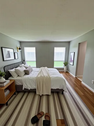 a spacious bedroom with a bed and a large mirror on a dresser