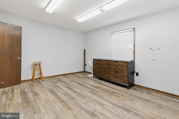 a view of an empty room with wooden floor and closet