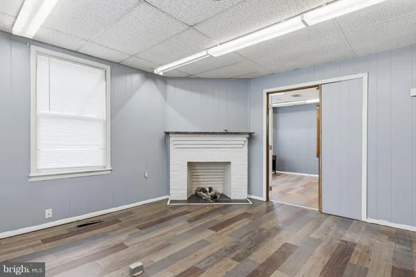 an empty room with windows and fireplace