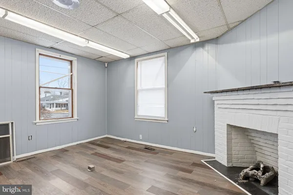 a view of a hallway with wooden floor and a bathroom