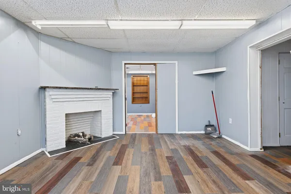 a view of empty room with wooden floor and fireplace