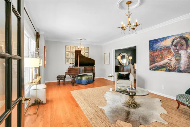 a dining room with furniture a chandelier and wooden floor
