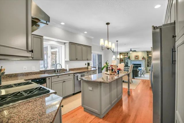 a kitchen with stainless steel appliances granite countertop a sink a stove and cabinets