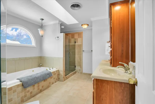 a spacious bathroom with a double vanity sink a mirror and a shower