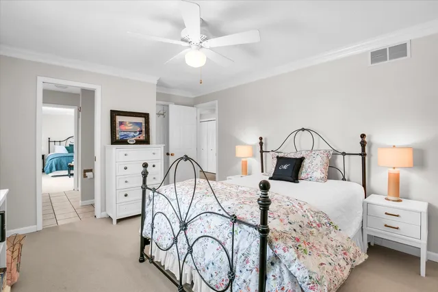a spacious bedroom with a bed and a chandelier