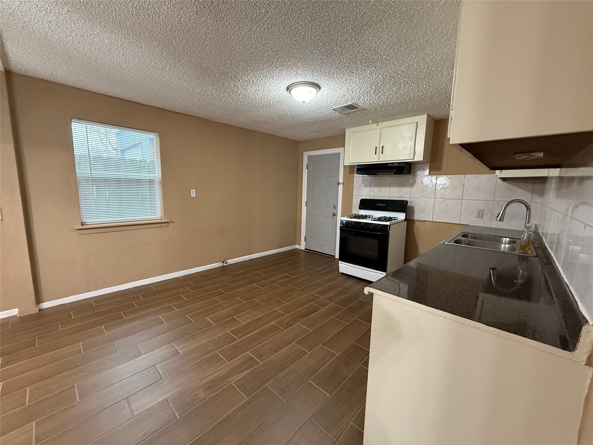 11216 Rusty Street Houston, TX 77093 - Photo 15 of 18 a kitchen with granite countertop a sink stove and cabinets