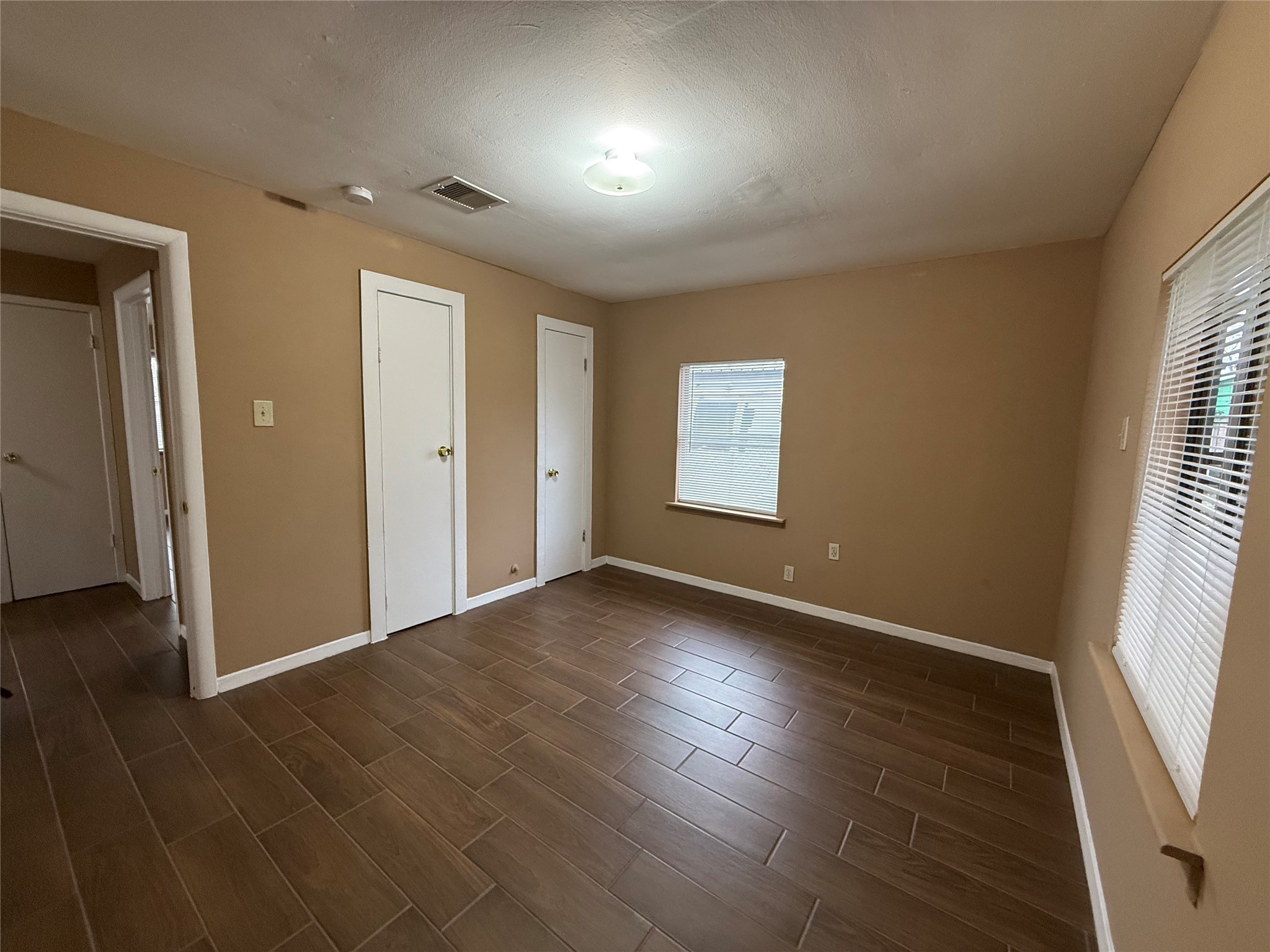11216 Rusty Street Houston, TX 77093 - Photo 3 of 18 an empty room with wooden floor and windows